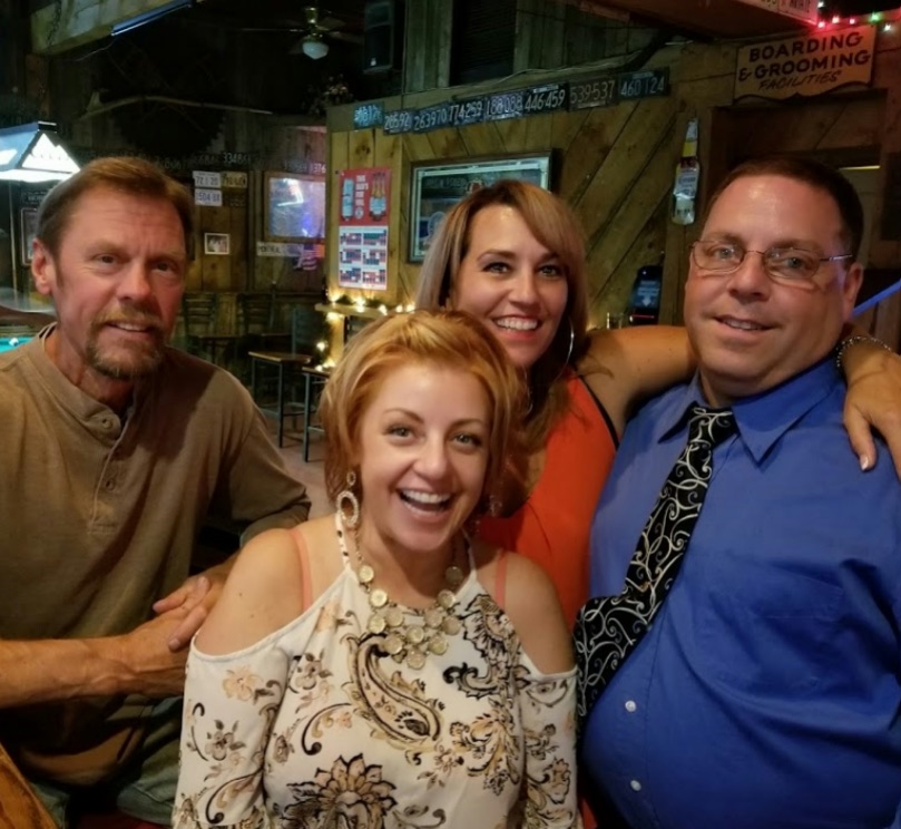 The owner of Key West Lounge smiling with customers at the bar in North Adams, MA